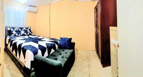 a bedroom with a bed and a couch in it at 3bedrm, 2 bthrm. 7East Greater Portmore in Portmore