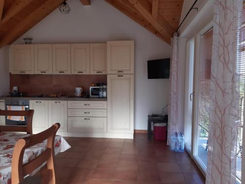 a kitchen with white cabinets and a large window at Casa giardino panoramico in Cannero Riviera