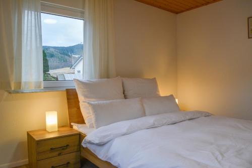 - une chambre avec un lit blanc et une fenêtre dans l'établissement Ferienwohnung Sonnenglück, à Bad Peterstal-Griesbach