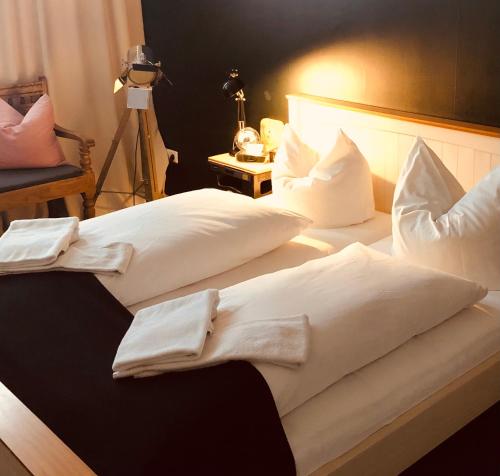 two beds with white sheets and pillows in a room at beans parc hotel jade in Wilhelmshaven