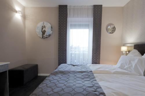 Un dormitorio con una cama grande y una ventana en Bubble Hotel és Rendezvényközpont en Zalaegerszeg