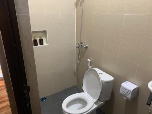 a small bathroom with a toilet and a shower at Tirtasuci House in Kuta