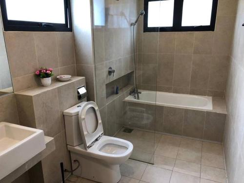 La salle de bains est pourvue de toilettes, d'une baignoire et d'un lavabo. dans l'établissement Orak Villa @ Kayangan Heights, à Shah Alam