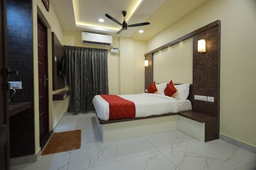 a bedroom with a bed with red pillows at JEYAM HOLIDAY HOME in Kanyakumari