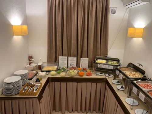a kitchen with a buffet of food on a counter at Optima Collection Troitska in Dnipro