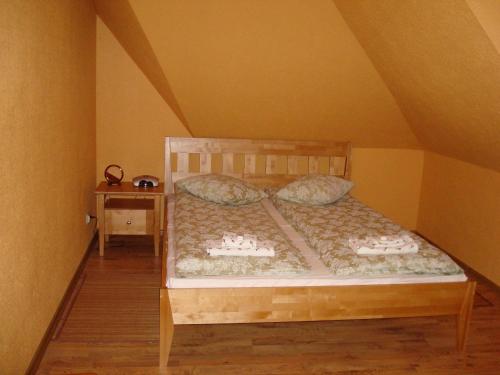 a wooden bed with pillows on it in a room at Sanders Motel in Smārde
