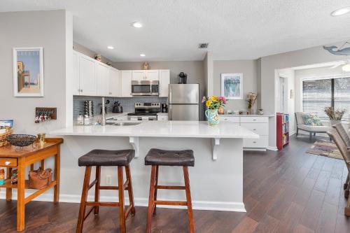 a kitchen with a large island with two bar stools at Harbour Oaks 606 in Saint Simons Island