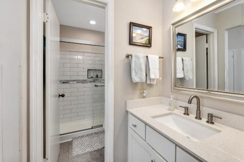 Baño blanco con lavabo y espejo en Harbour Oaks 606 en Saint Simons Island