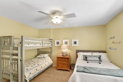 sypialnia z 2 łóżkami piętrowymi i wentylatorem sufitowym w obiekcie Turtle Cove w mieście Wyspa St. Simons
