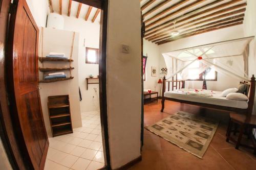 a room with a bedroom and a bed in a room at Kipepeo Lodge Zanzibar in Jambiani