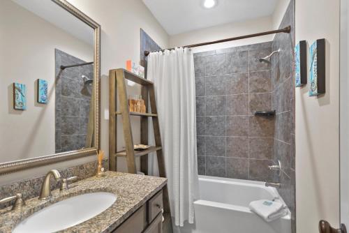 a bathroom with a shower and a sink and a tub at Kirkland Cottage in Saint Simons Island