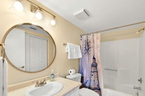 La salle de bains est pourvue d'un lavabo, de toilettes et d'un miroir. dans l'établissement Shipwatch # 304, à East End