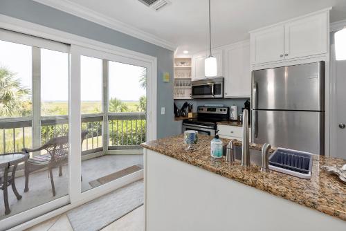 a kitchen with a stainless steel refrigerator and a balcony at Birds Eye View in Saint Simons Island