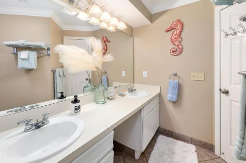a bathroom with two sinks and a mirror at Birds Eye View in Saint Simons Island