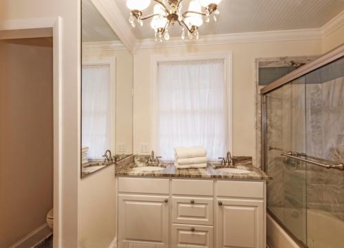La salle de bains est pourvue de 2 lavabos et d'une douche. dans l'établissement 120 Druid Oaks Lane, à Île de Saint-Simon