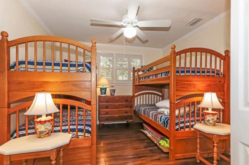 two bunk beds in a room with a ceiling fan at 120 Druid Oaks Lane in Saint Simons Island