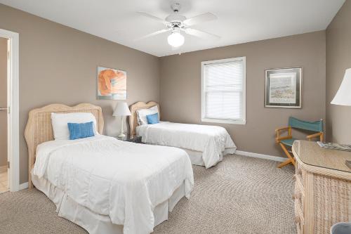a bedroom with two beds and a ceiling fan at 221 Olive Way in Saint Simons Island