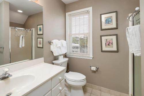 La salle de bains est pourvue de toilettes blanches et d'un lavabo. dans l'établissement 221 Olive Way, à Île de Saint-Simon