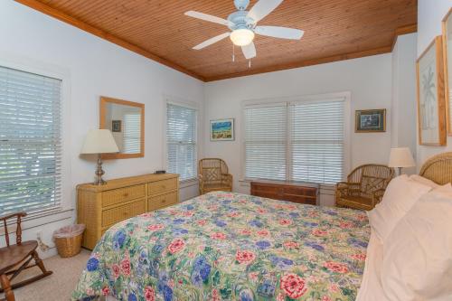 een slaapkamer met een bed en een plafondventilator bij Island Breeze in Saint Simons Island
