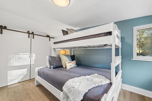 - une chambre avec des lits superposés blancs et un mur bleu dans l'établissement Tee Times and Tides, à Île de Saint-Simon