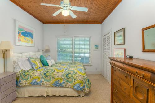 a bedroom with a bed and a ceiling fan at Lesser Breeze in Saint Simons Island