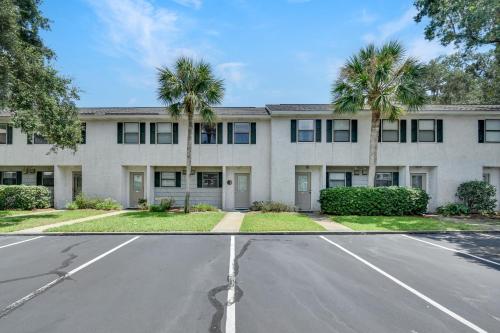 an empty street in front of a building with palm trees at Courtyard Villa C-4 Butterfly Villa in Saint Simons Island