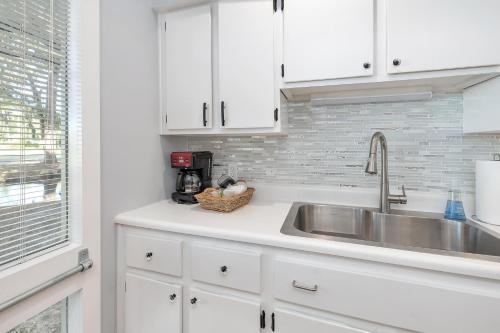 una cucina con mobili bianchi e un lavandino di Fairway Villa #410 a Saint Simons Island