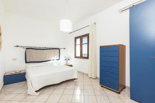 1 dormitorio con 1 cama y vestidor azul en Appartamento Vista Mare, en Santa Maria Navarrese