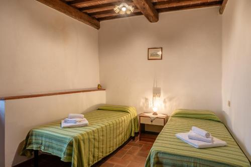 two twin beds in a room with a lamp at Agriturismo Fadanelli - Il Forno in Lamporecchio