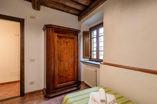 1 dormitorio con 1 cama y puerta de madera en Agriturismo Fadanelli - Il Forno en Lamporecchio