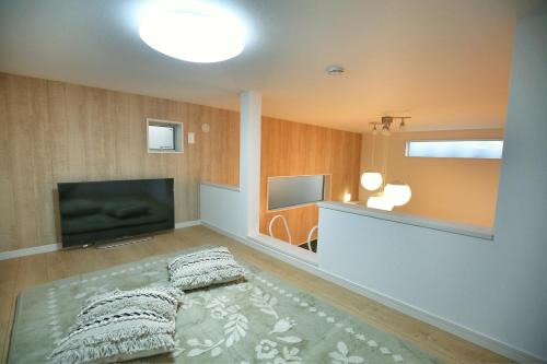 a living room with a flat screen tv and a bed at kameido k hotel in Tokyo