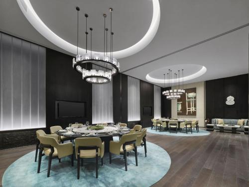 a dining room with a table and chairs and chandeliers at Hilton Nanjing Niushoushan in Nanjing