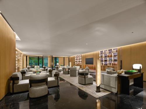 a lobby with couches and chairs in a building at Hilton Nanjing Niushoushan in Nanjing