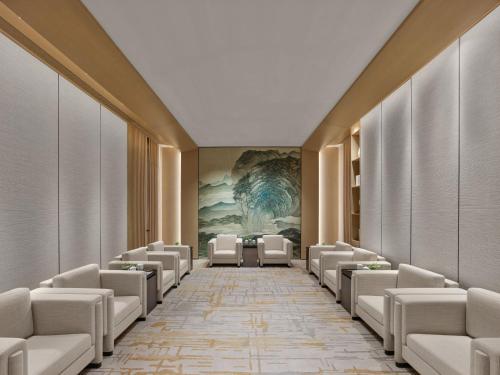 a row of chairs in a waiting room with a painting at Hilton Nanjing Niushoushan in Nanjing