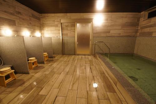 a bathroom with a hot tub and a room with toilets at 京ごはんと露天風呂の宿 ゆのはな 月や 