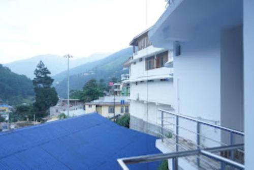 a balcony of a building with a blue roof at Hotel 7 Eleven Dirang in Dirang Dzong