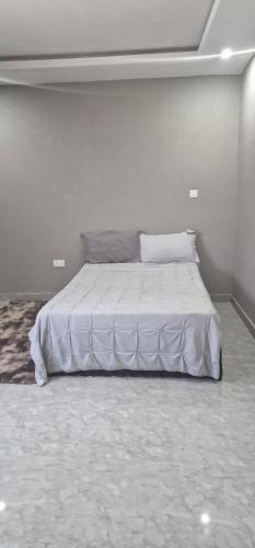 a bedroom with a white bed in a room at Salama Apartments in Lusaka