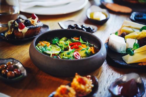 a wooden table with a bowl of food on it at Bengodi Boutique Hotel in Eceabat