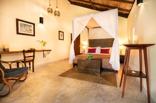 a bedroom with a bed with a mosquito net at Club Mango Resort in Kalpitiya
