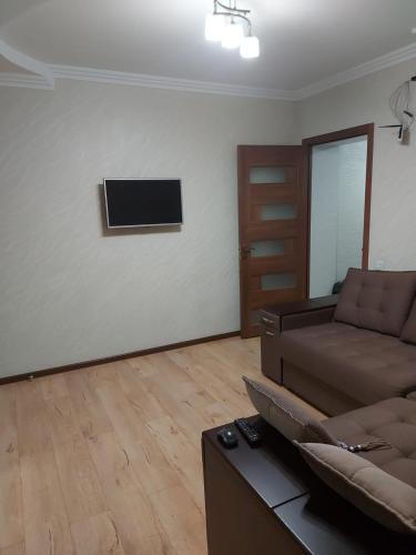 sala de estar con sofá y TV en la pared en Апартамент 2-х комнатный en Făleşti