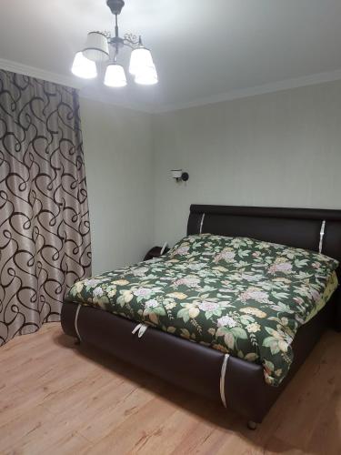 1 dormitorio con 1 cama con edredón verde en Апартамент 2-х комнатный en Făleşti