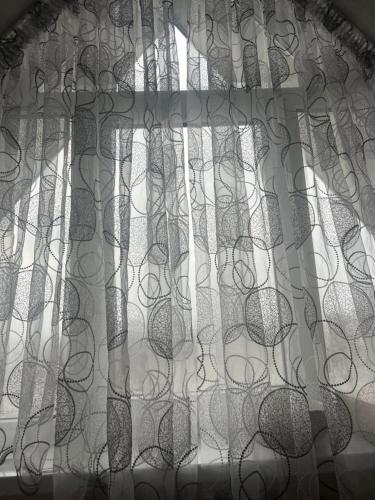 uma janela com cortinas pretas e brancas em Апартамент 2-х комнатный em Făleşti