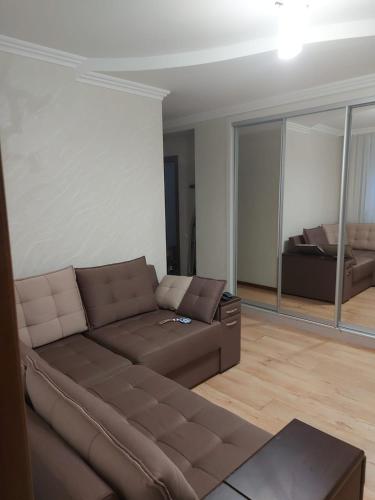 a living room with a brown couch and a bed at Апартамент 2-х комнатный in Făleşti