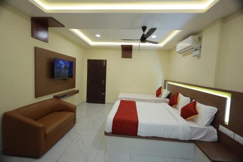 a hotel room with a bed and a couch at JEYAM HOLIDAY HOME in Kanyakumari