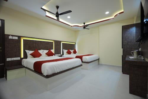a bedroom with two beds with red pillows at JEYAM HOLIDAY HOME in Kanyakumari