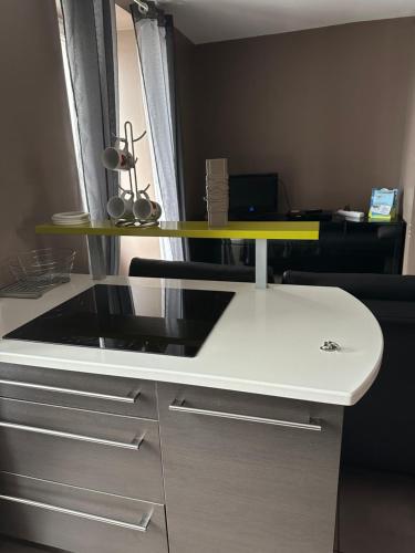 - un bureau blanc avec un comptoir jaune dans l'établissement Appartement Granville, à Granville