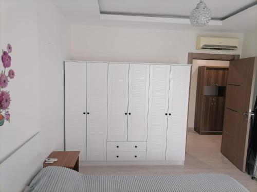 een keuken met witte kasten en een tafel in een kamer bij Marina 1 in Antalya