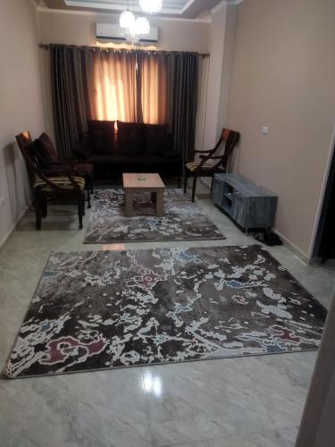 Hurghada City Apartment2 في الغردقة: غرفة معيشة مع أريكة وسجادة