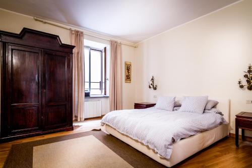 a bedroom with a large bed and a wooden cabinet at Lake Charming Apartment in Cernobbio