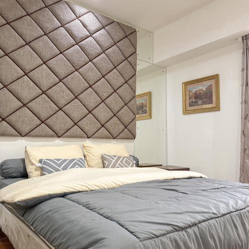 a bedroom with a large bed with a wall at Senayan Jakarta Oasis - Gym, Pool, Netflix in Jakarta